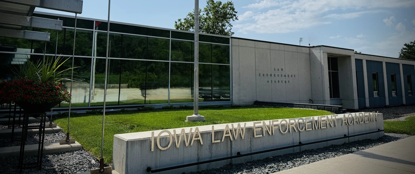 Iowa Law Enforcement Academy sign with building behind made of glass and concrete