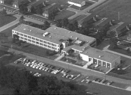 ILEA building with additional wings built and a parking lot